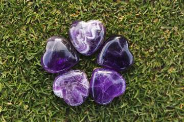 amethyst crystals heart stones in circle on grass 