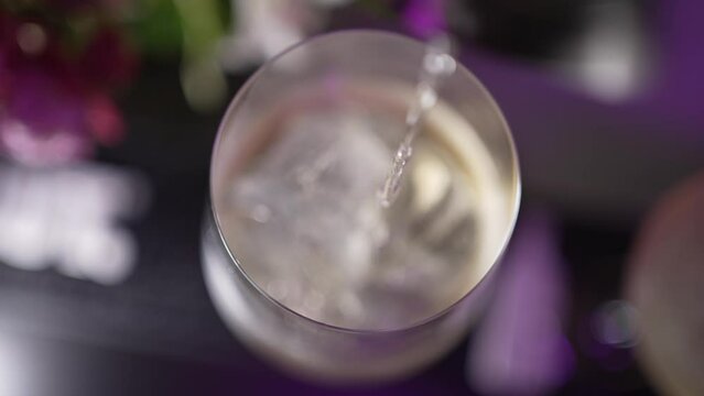 Pour alcohol into a glass with ice