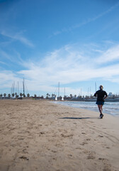 Female athlete running along the beach shore