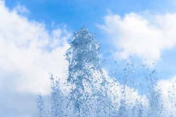 Obraz na płótnie Canvas Water fountain jetting bodies of water up to cloudy blue sky
