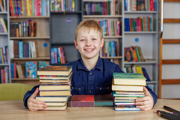 Child boy reads book from bookshelves in library. Bookstore concept, education and knowledge.