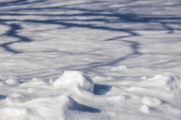 Obraz premium Full frame landscape texture background of snow covered ground, beginning to melt under natural sunlight 