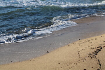 White foamy sea waves cover the sand