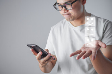 The man in glasses is serious with some assessments. Person portrait on grey background. Evaluation and satisfaction concept with virtual emoji.