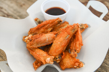 fried chicken wings with sauce thai food on wooden table food background