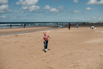 Little girl play along the beach by the sea.
