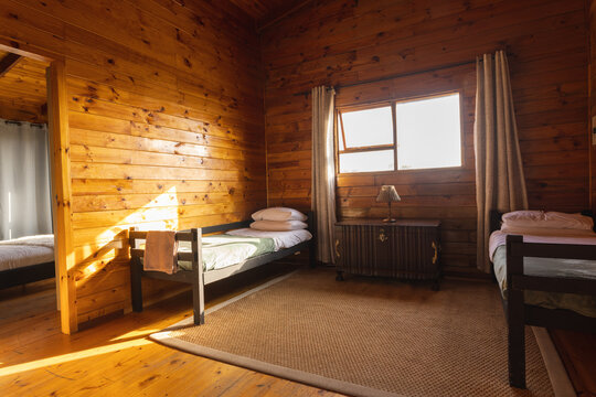 Empty cosy room in log cabin with two beds and big carpet