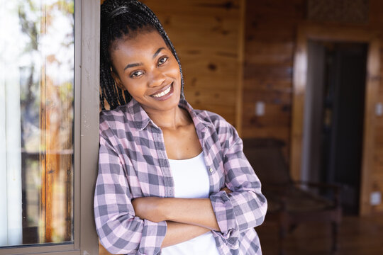 Portrait of happy african american woman spending time in log cabin
