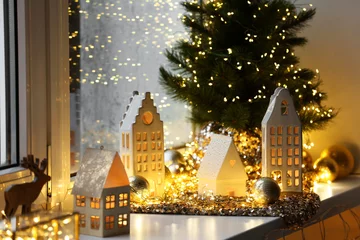 Deurstickers Beautiful decorative houses, baubles and small Christmas tree on window sill indoors © New Africa