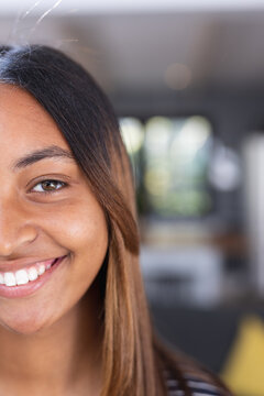Portrait of happy biracial teenage girl smiling in kitchen