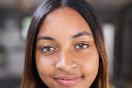 Portrait of happy biracial teenage girl smiling in kitchen