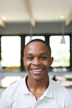 Vertical image of happy african american teenage boy looking at camera