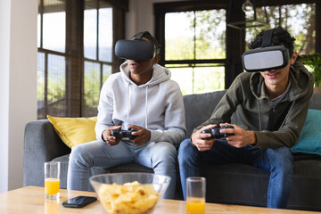 Image of diverse male teenage friends with vr glasses playing video games at home