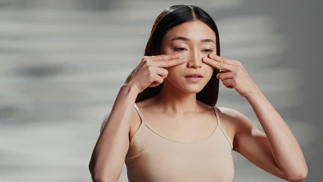 Confident model using moisturizing cream for routine, applying face serum on cheecks and promoting beauty cosmetics or products. Gentle woman with luminous radiant skin, self love.
