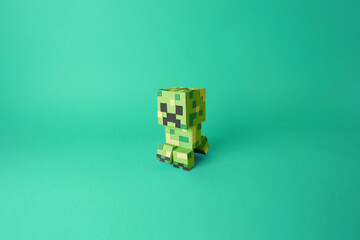 Fototapeta premium Papercraft of an isolated video game character from Minecraft, Creeper. Colored green paper cut-out model art