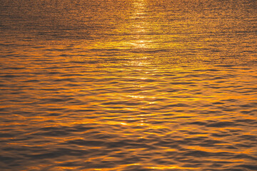 Sunset water reflect ripples at sun light. Abstract golden reflection on water sunset