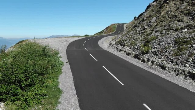 Drone flying along panoramic D90 road with valley in background, Col de la Loze mountain pass in French Alps, France. Aerial view