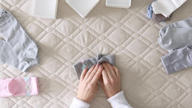 Women's hands fold socks in various convenient ways for storage. Master Class.