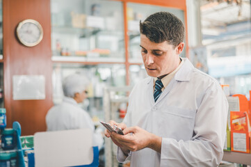 Fototapeta premium Pharmacist checking Checks Inventory of Medicine, Drugs, Vitamins and prescription medication checks in modern pharmacy.