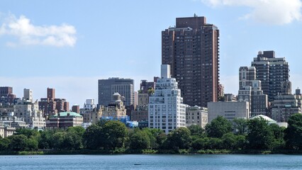 Fototapeta na wymiar city skyline long exposure photo of a view of the city towers from the lake from the central park in a day of spring, manhattan island, new york city nature plants and outdoors in spring season