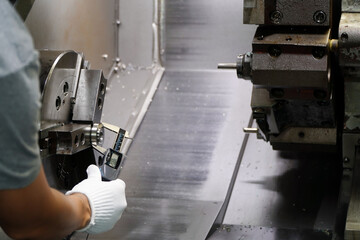Quality control manufacturing.Hands of an engineer measures a metal part with a digital vernier caliper