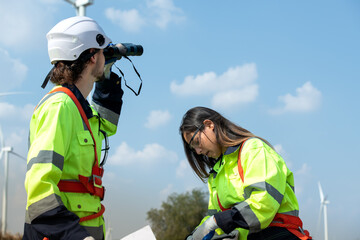 Man and female engineer stationed at the Natural Energy Wind Turbine site. with daily audit tasks of major wind turbine operations that transform wind energy into electrical electricity