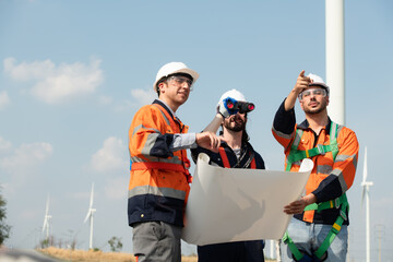 Surveyor and engineer Examine the efficiency of gigantic wind turbines that transform wind energy into electrical energy that is then used in daily life.