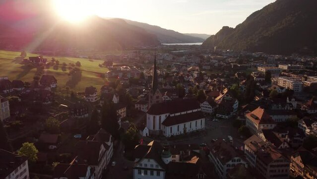 Orbiting  around the city of Lucern at sunet, showing the skyline and churches with towering mountains