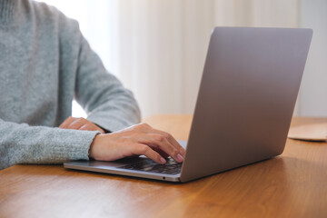 Closeup image of a woman working on laptop computer at home