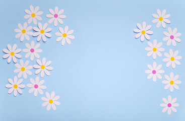 Fototapeta na wymiar Fondo de color azul pastel con margaritas blancas de papel, ilustra la primavera en tonos pastel con paper cut