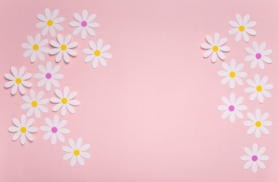 Fondo de color rosa pastel con margaritas blancas de papel, ilustra la primavera en tonos pastel con paper cut