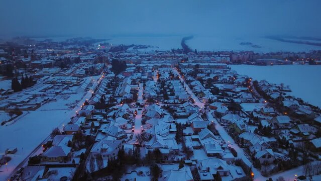 Houses covered with snow on a winter night. Street lamp lights illuminate the white sidewalks. Family housing and real estate for a happy life for starting families. Svitavy city, Czech Republic