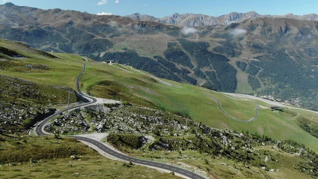 Deserted curved serpentine road on Col de la Loze mountain alpine pass, France. Aerial drone panoramic view