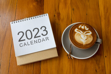 calendar 2023 and coffee cup on wood table, Top view and copy space. Xmas, Happy New Year, Goals, Resolution, To do list, Strategy and Plan concept