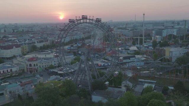 Vienna Prater, sun set behind ferris wheel with skyline in the background.