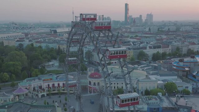 Closeup circling shot, Vienna during sunset with famous ferris wheel.