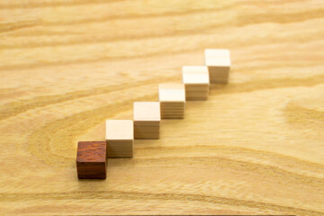 始めに赤いウッドキューブを置いた6個のステップの木目の背景