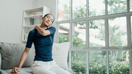 Unhappy Asian woman suffering from pain in the shoulder