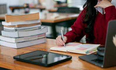 Businesswoman or student writing note on diary at office desk