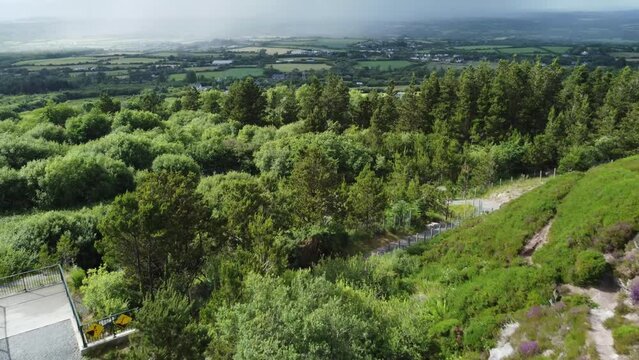 Aerial pull out of old Irish quarry overlooking green fields