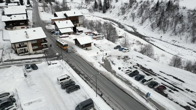 Aerial shot of a small village in a ski region. Wiler in the L&ouml;tschental. A bus is driving through the street. Ski tourists arrive