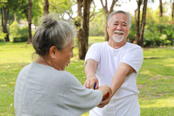 Obraz premium Happy and smiling asian senior couple doing arm work out and lifting dumbbell exercise with relaxation for healthy in park outdoor after retirement. Health care elderly outdoor lifestyle concept.