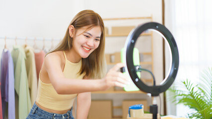 Online selling concept, Fashion designer checks smartphone to prepare live streaming sells clothes