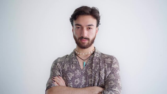 Young queer latin gay man with his arms crossed staring at the camera. 4k video.