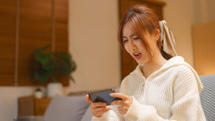 Nightlife concept, Young woman playing game on smartphone with excited in night time at winter