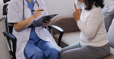 Obraz premium Homecare nursing service and elderly people cardiology healthcare. Close up of young hispanic female doctor nurse check mature caucasian man patient heartbeat using stethoscope during visit