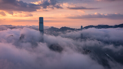 An aerial view of Hong Kong city at sunrise with a sea of clouds and two of Hong Kong's landmarks