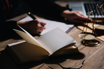 Justice and law concept.Male judge in a courtroom with the gavel, working with, computer and docking keyboard, eyeglasses, on table in morning light