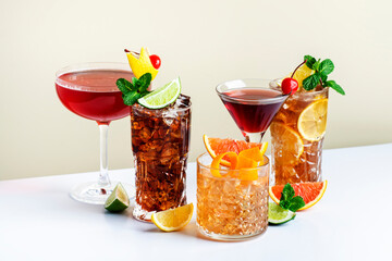 Summer alcoholic cocktails: rum cola, long island ice tea, manhattan, cosmopolitan, old fashioned - trendy popular drinks and beverages for cocktail party. Beige background