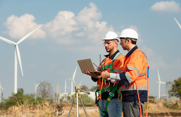 Surveyor and engineer Examine the efficiency of gigantic wind turbines that transform wind energy...